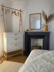 a bedroom with a bed and a dresser and a mirror at Le Grand Est Scandinave, centre ville, proche cathédrale in Reims