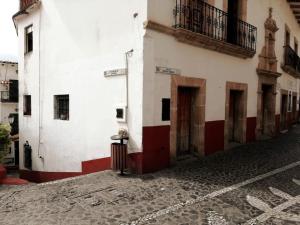 an empty street with a white and red building at La cabaña del TIO PEPE in Taxco de Alarcón