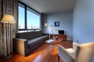una sala de estar con un sofá y una mesa en Exe Sevilla Palmera, en Sevilla