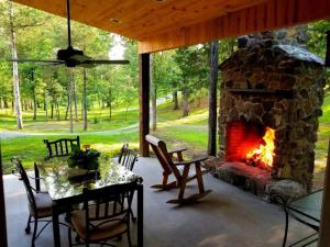 a patio with a stone fireplace and a table and chairs at Royal Suite at White Lotus Eco Spa Retreat in Stanardsville