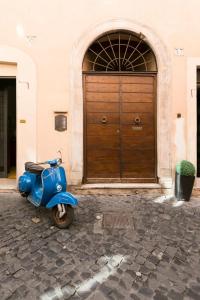 a blue scooter parked in front of a building at Balestrari Boutique Apartment in Rome