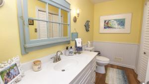 a bathroom with a sink and a toilet and a mirror at Oceanside, Private Pool, Walking distance to town of Duck, Foosball, T3, Bella Vita in Duck +27 photos