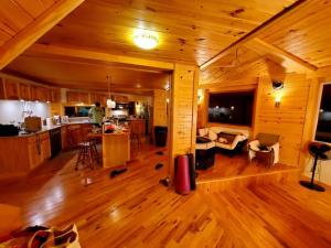 uma sala de estar e cozinha em plano aberto num chalé de madeira em Zen River Retreat em Stanardsville