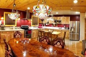 a kitchen with a wooden table with chairs and a tableasteryasteryasteryasteryastery at Balcony Suite at White Lotus Eco Spa Retreat in Stanardsville +18 photos