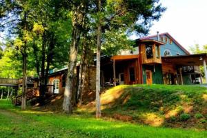 a large house with trees in front of it at Balcony Suite at White Lotus Eco Spa Retreat in Stanardsville