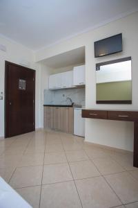 a large kitchen with a flat screen tv on a wall at Villa Amalia Sun Beach in Nea Vrasna