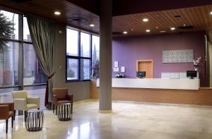 Una zona de espera en un hospital con sillas y una sala de espera. en Exe Sevilla Palmera, en Sevilla
