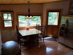 a dining room with a table and a refrigerator at Log Cabin on the River in Stanardsville