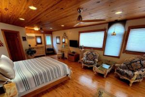 a large bedroom with a bed and two chairs at Cascina Rococo at White Lotus Eco Spa Retreat in Stanardsville