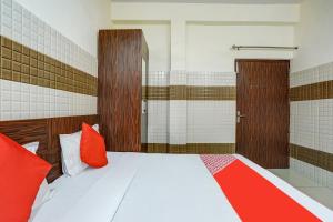 sypialnia z łóżkiem z czerwonymi poduszkami w obiekcie Super OYO Hotel 7 Sky w mieście Ludhiana