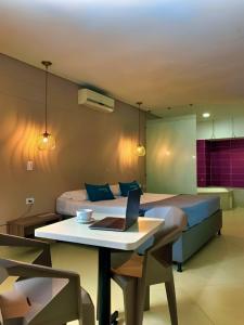 um quarto com uma cama e uma mesa com um computador portátil em Hotel Perlatto em Bello