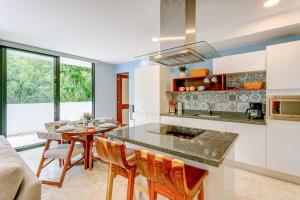 a kitchen and dining room with a table and chairs at Tropical Retreat Pools Golf Gym Jungle Views in Akumal