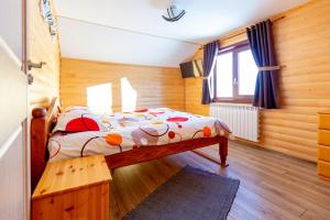 a bedroom with a bed in a wooden room at Cabana Lunca in Tîrgu Neamţ