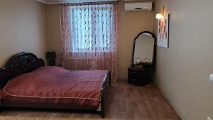 a bedroom with a bed and a mirror and a window at Apartment Tiraspol on Lenina 7 in Tiraspol