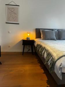 um quarto com uma cama e uma mesa com um candeeiro em The South Suite - trendy duplex op het Zuid em Antuérpia