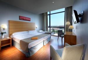 Una habitación de hotel con una cama, un escritorio y una silla. en Exe Sevilla Palmera, en Sevilla 18 fotos más