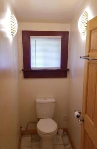 uma casa de banho com um WC branco e uma janela em Shire Suite at White Lotus Eco Spa retreat em Stanardsville