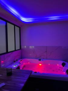y baño con bañera con luces rojas. en Love room nantais, en Nantes
