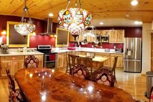 a kitchen with a wooden table with chairs and a tableasteryasteryasteryasteryastery at Castle Suite at White Lotus Eco Spa Retreat in Stanardsville