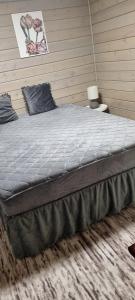 a large bed in a bedroom with a wall at Sydalen house in Kleppstad