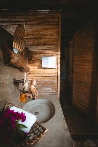 a bathroom sink with a teddy bear sitting on it at Isla Fuerte Eco House in Puerto Limón