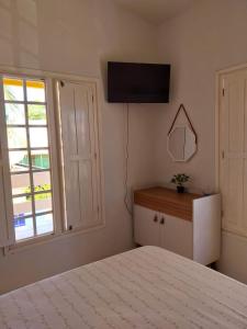 ein Schlafzimmer mit einem Bett und einem TV an der Wand in der Unterkunft Linda Casa de Praia com piscina, área verde - MOBILIADA à 150 m do mar em Tamandaré-PE in Tamandaré