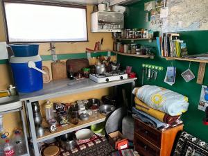 a cluttered kitchen with a green wall and shelves at Gezgin Evi in Kayseri