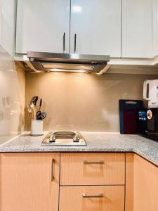 a kitchen with a stove top in a kitchen at Thompson Suites - 2-beds near OKADA, Bayshore 2 in Manila +11 photos