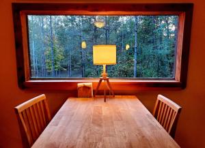 un tavolo con una lampada davanti a una finestra di Glade Cottage at White Lotus Eco Spa Retreat a Stanardsville