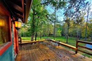 a deck with benches and a view of the woods at Glade Cottage at White Lotus Eco Spa Retreat in Stanardsville