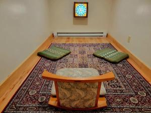 a room with a table and two pillows on a rug at Glade Cottage at White Lotus Eco Spa Retreat in Stanardsville