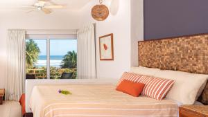 a bedroom with a bed with a view of the ocean at Las Flores Resort in Chirilagua +33 photos