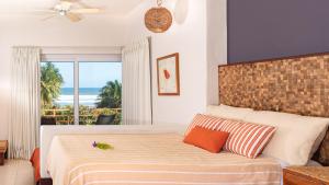 a bedroom with a bed with a view of the ocean at Las Flores Resort in Chirilagua