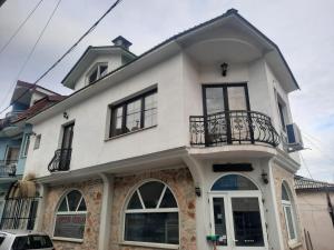 a white house with a balcony on a street at Apartment's DAMJAN - Kruševo in Kruševo