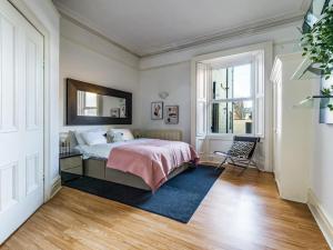 a bedroom with a bed and a mirror on the wall at Longsands Beach Apartment 1 Tynemouth Free Onsite Parking in Tynemouth