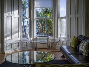 a living room with a glass table and a couch at Longsands Beach Apartment 1 Tynemouth Free Onsite Parking in Tynemouth