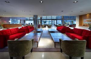 eine Lobby mit roten Sofas und Tischen in einem Gebäude in der Unterkunft Eurostars Grand Marina Hotel GL in Barcelona