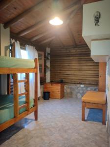 Zimmer mit einem Etagenbett, einem Tisch und einem Stuhl in der Unterkunft Cabaña de troncos en Nono, Córdoba in Nono