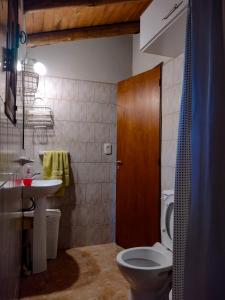 ein Badezimmer mit Toilette und Waschbecken in der Unterkunft Cabaña de troncos en Nono, Córdoba in Nono