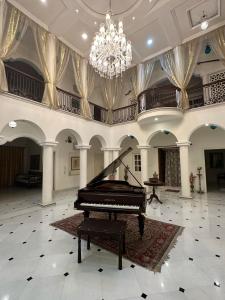a grand piano in a large room with a chandelier at Radhe Krishna Niwas in Udaipur