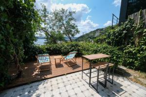 una terraza de madera con 2 sillas y una mesa en Maison Détroit : Iconic 3Br Triplex w/ GREAT Views, en Estambul