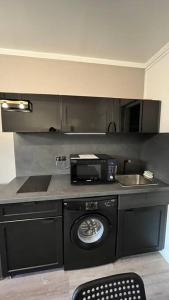 uma cozinha com uma máquina de lavar roupa e um micro-ondas em Appartement Porte de Vincennes Nation - 2 pers em Saint-Mandé