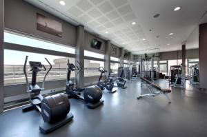 einen Fitnessraum mit mehreren Laufbändern und Crosstrainern in der Unterkunft Eurostars Grand Marina Hotel GL in Barcelona