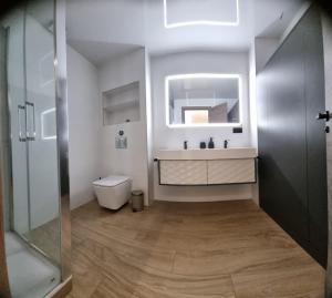 Un baño con lavabo, inodoro y espejo. en Habitación céntrica de Lujo Gv 4, en Valencia 29 fotos más