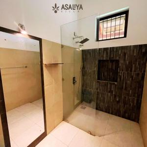 y baño con ducha y puerta de cristal. en Asaliya Villa, en Aswalapitiya