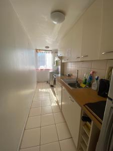 a small kitchen with white cabinets and a sink at Depto barrio universitario in La Serena