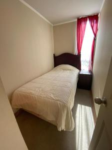 a small bedroom with a bed and a window at Depto barrio universitario in La Serena