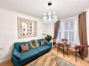 Una sala de estar con un sofá azul y una mesa de cristal. en Central Cambridge Fig Tree House, en Cambridge