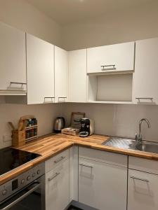 una cocina con armarios blancos y fregadero en BRAN: Design - Apartment Küche, Parken ,Netflix, en Bad Rothenfelde