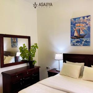 1 dormitorio con cama y espejo en Asaliya Villa en Aswalapitiya